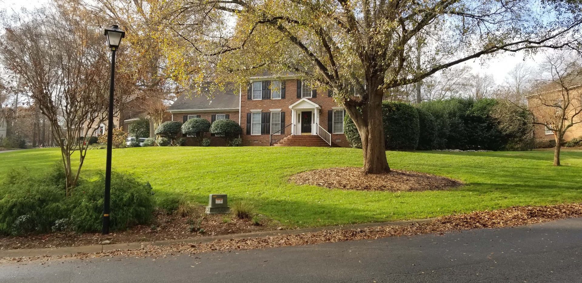 Lush green lawn at a brick colonial home